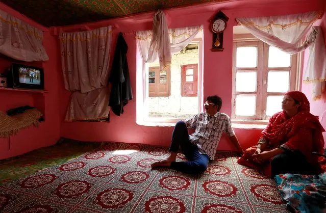 Members of a family watch television in their home in Srinagar as the city remains under curfew following weeks of violence in Kashmir, August 21, 2016. (Photo by Cathal McNaughton/Reuters)