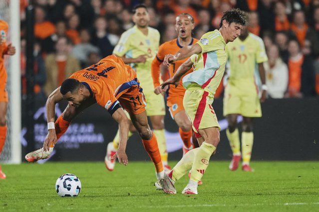 Netherlands' Cody Gakpo, left, duels for the ball with Spain's Robin Le Normand during the UEFA Nations League quarterfinal first leg match between the Netherlands and Spain at De Kuip stadium in Rotterdam, Netherlands, Thursday, March 20, 2025. (Photo by Peter Dejong/AP Photo)