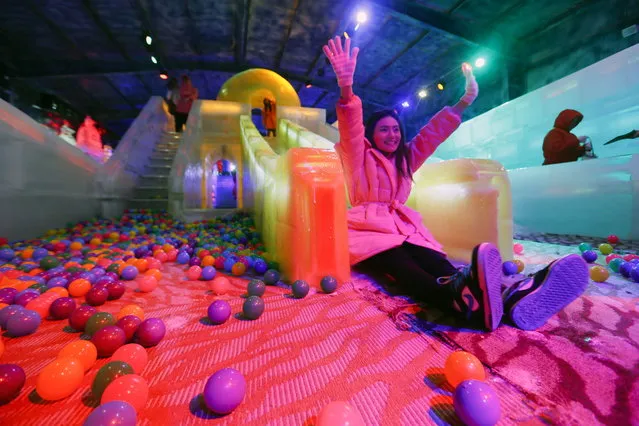 A Thai woman poses for a photograph as she slides down an ice sculpture at the newly opened Harbin Ice Wonderland in Bangkok, Thailand, October 8, 2014. The leisure park is kept at a temperature of minus 15 degrees Celsius and features ice sculptures created by Chinese artists from Harbin. The 80-million-baht park was opened by Singapore's Century Ice Wonderland Pte Ltd.  (Photo by Wallace Woon/EPA)