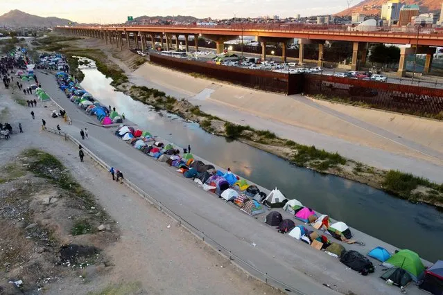 Aerial view of migrants camping on the banks of the Rio Bravo river (or Rio Grande river, as it is called in the US) in Ciudad Juarez, Chihuahua state, Mexico, taken on November 15, 2022. A US federal judge ruled on November 15 that the government could not use public health rules to block the entry of asylum-seeking migrants, marking the apparent end of a controversial Donald Trump-era policy that has been criticized as cruel and ineffective. (Photo by Herika Martinez/AFP Photo)
