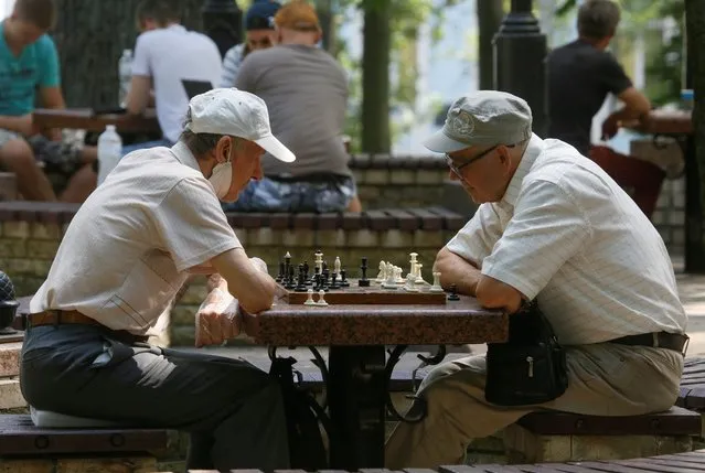 Two men play an outdoor chess game on a sunny day in a city park in Kiev, Ukraine, on July 20, 2020. The United Nations General Assembly proclaimed July 20 as World Chess Day to mark the date of the establishment of the International Chess Federation (FIDE) in Paris in 1924. (Photo by Efrem Lukatsky/AP Photo)
