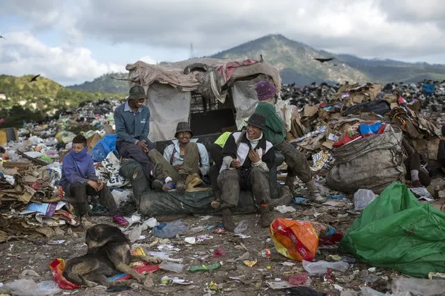 Men and boys joke around as they take a break from collecting plastic and cardboard to resell, at “El Crematorio” or The Crematory, the biggest dump on the outskirts of Tegucigalpa, Honduras, Friday, November 24, 2017. (Photo by Rodrigo Abd/AP Photo)
