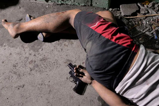 The body of a man is pictured with a gun under his hand, whom police said was killed during a drug bust operation on “Shabu” (Meth), in Manila, Philippines on Aug. 18, 2016. (Photo by Ezra Acayan/Reuters)