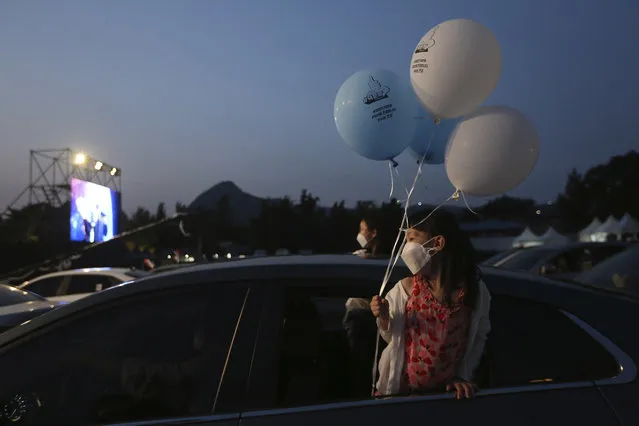 Girls in a car watch a drive-in concert at Gyeongbok Palace parking lot in Seoul, South Korea, Friday, July 17, 2020. (Photo by Ahn Young-joon/AP Photo)