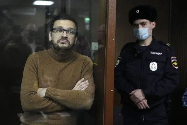 Russian opposition activist and former municipal deputy of the Krasnoselsky district Ilya Yashin stands in a cage in a courtroom prior to a hearing in Moscow, Russia, Tuesday, November 29, 2022. Yashin, one of the few prominent opposition figures to have remained in the country amid an intensifying crackdown on dissent was arrested in June in a Moscow park and later was charged with spreading false information about the Russian military – a new criminal offense for which he faces up to 10 years in prison if convicted. (Photo by Alexander Zemlianichenko/AP Photo)