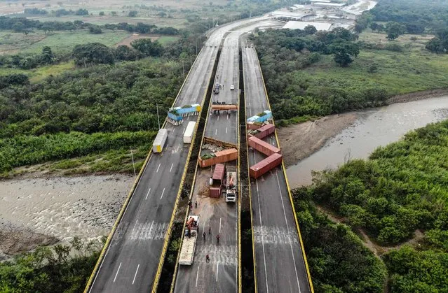 This aerial view shows Venezuelan state workers removing containers at the “Tiendita” international bridge on the border between Colombia and Venezuela in Cucuta, Colombia, on December 14, 2022. Venezuelan President Nicolas Maduro said on December 12 his country would fully reopen its land border with Colombia on January 1, 2023, completing a negotiating process that began in September with the two South American neighbors reestablishing diplomatic ties. (Photo by Edinson Estupinan/AFP Photo)