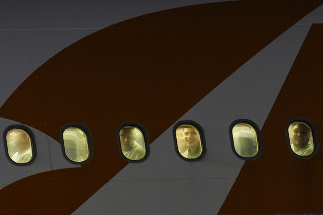 Venezuelan migrants deported from the United States peer through their plane windows as they arrive at the Simon Bolivar International Airport in Maiquetia, Venezuela, March 24, 2025. (Photo by Ariana Cubillos/AP Photo)