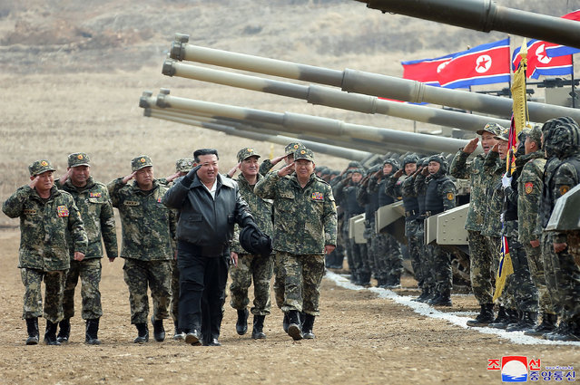 This picture taken on March 13, 2024 and released by North Korea's official Korean Central News Agency (KCNA) on March 14 shows North Korean leader Kim Jong Un (C) saluting personnel during a training competition between the combined forces of the Korean People's Army tank crews at an undisclosed location in North Korea. (Photo by KCNA via KNS/AFP Photo)