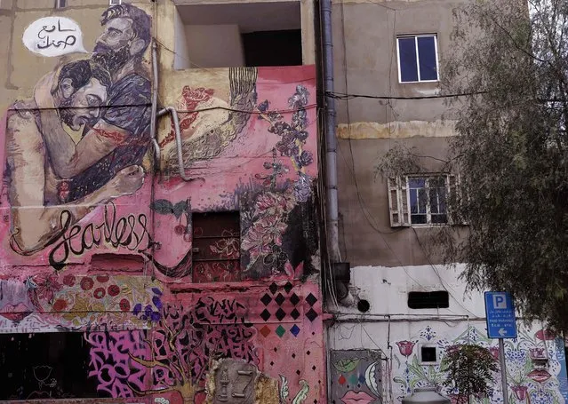 A picture shows a mural on a wall of a building in Ashrafiyeh, on the eastern outskirts of the Lebanese capital Beirut, on January 15, 2018. The writing in Arabic reads: “I hear your silence”. The mural is a collaboration between the Fearless Collective and the Arab Foundation for Freedoms and Equality's Tayf program. The mural is the result of a workshop by the Fearless collective around the theme of masculinities and silence. This workshop was done with Beirut where many young gay and bisexual men took part in a story telling and sharing exercise which developed the mural ideas and its context. (Photo by Joseph Eid/AFP Photo)