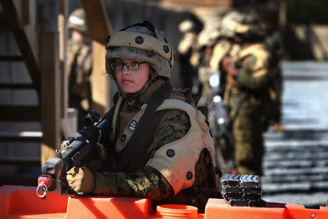 Pvt. Chloe Osborne from Hillsboro, Oregon stands guard at a checkpoint during a war games exercise during Marine Combat Training (MCT) on February 20, 2013 at Camp Lejeune, North Carolina.  Since 1988 all non-infantry enlisted male Marines have been required to complete 29 days of basic combat skills training at MCT after graduating from boot camp. MCT has been required for all enlisted female Marines since 1997. About six percent of enlisted Marines are female.  (Photo by Scott Olson)