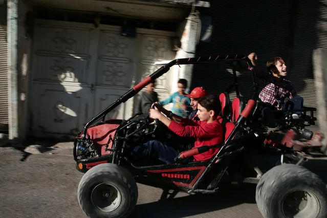 A boy drives a vehicle on the last day of Eid al-Adha celebrations in the rebel held besieged town of Hamouriyeh, eastern Ghouta, near Damascus, Syria September 15, 2016. (Photo by Bassam Khabieh/Reuters)