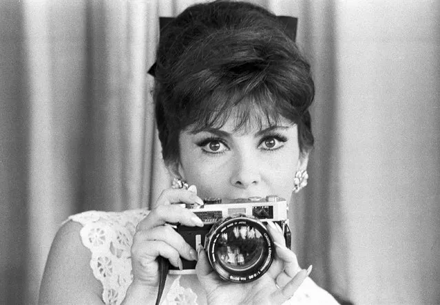 Italian movie star Gina Lollobrigida shows a 0.95 super-grand-angle lens mount on a 35mm camera, as she presents her collection of photographic equipment at her home on the ancient Appian Way on the outskirts of Rome, July 2, 1964. (Photo by Girolamo di Majo/AP Photo)