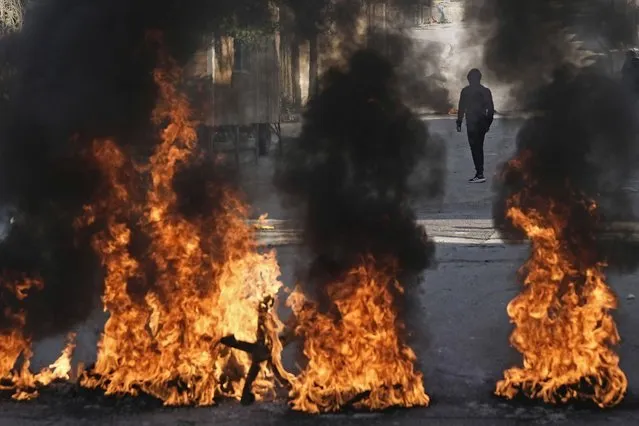 Palestinian demonstrators burn tires in a protest against a deadly Israeli army raid at Aida Refugee camp, in the West Bank city of Bethlehem, Thursday, January 26, 2023. During the raid in the West Bank town of Jenin, Israeli forces killed at least nine Palestinians, including a 60-year-old woman, and wounded several others, Palestinian health officials said, in one of the deadliest days of fighting in years. The Israeli military said it was conducting an operation to arrest militants when a gun battle erupted. (Photo by Mahmoud Illean/AP Photo)
