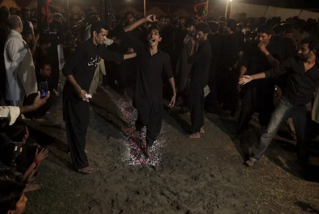 A Pakistani Shi'ite Muslim shouts religious slogans while walking on hot coals during an early morning religious gathering ahead of the Ashura festival in Lahore, Pakistan October 22, 2015. Ashura, which falls on the 10th day of the Islamic month of Muharram, commemorates the death of Imam Hussein, grandson of Prophet Mohammad, who was killed in the 7th century battle of Kerbala. (Photo by Mohsin Raza/Reuters)