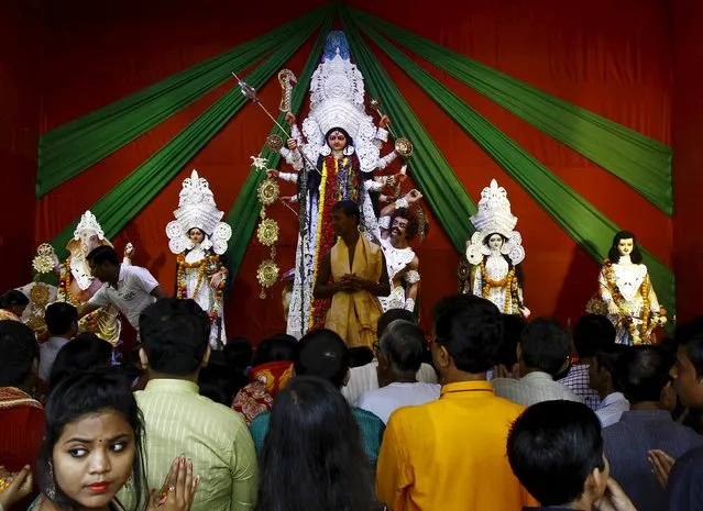 Devotees gather to worship an idol of the Hindu goddess Durga at a pandal or temporary platform during the Durga Puja festival in Kolkata, India, October 21, 2015. The Durga Puja festival is celebrated from October 19 to 22, which is the biggest religious event for Bengali Hindus. Hindus believe that the goddess Durga symbolises power and the triumph of good over evil. (Photo by Rupak De Chowdhuri/Reuters)