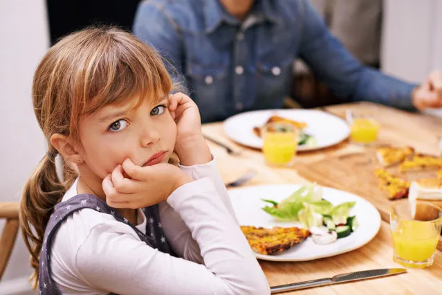 A little girl sitting at the dinner table with a sulky look. (Photo by Peopleimages/Getty Images/iStockphoto)