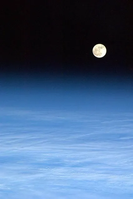 The moon rises over a light blanket of clouds in a March 4, 2013 photo taken from the International Space Station by Canadian astronaut Chris Hadfield. (Photo by Chris Hadfield/CSA via AFP Photo)