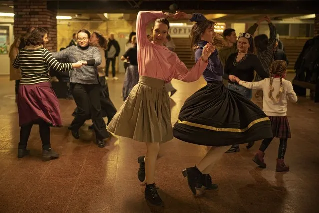 People dance in a subway station during an air raid alarm in Kyiv, Ukraine, Wednesday, March 1, 2023. (Photo by Vadim Ghirda/AP Photo)