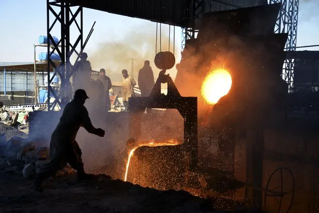Afghan labourers work at an iron factory on the outskirts of Kandahar province, on February 6, 2023. (Photo by Sanaullah Seiam/AFP Photo)