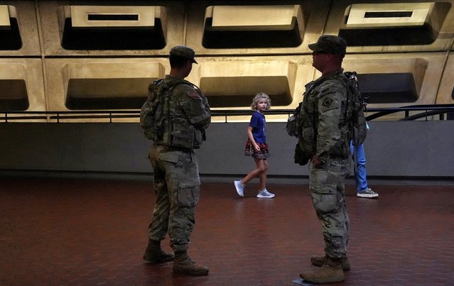A child walks past two members of the National Guard from Mississippi posted in the Metro weeks after U.S. President Donald Trump deployed the National Guard and ordered an increased presence of federal law enforcement, in Washington, D.C., U.S., September 5, 2025. (Photo by Leah Millis/Reuters)