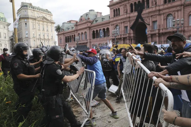 Soccer fans waiting to see Diego Maradona lying in state clash with police outside the presidential palace in Buenos Aires, Argentina, Thursday, November 26, 2020. (Photo by Rodrigo Abd/AP Photo)