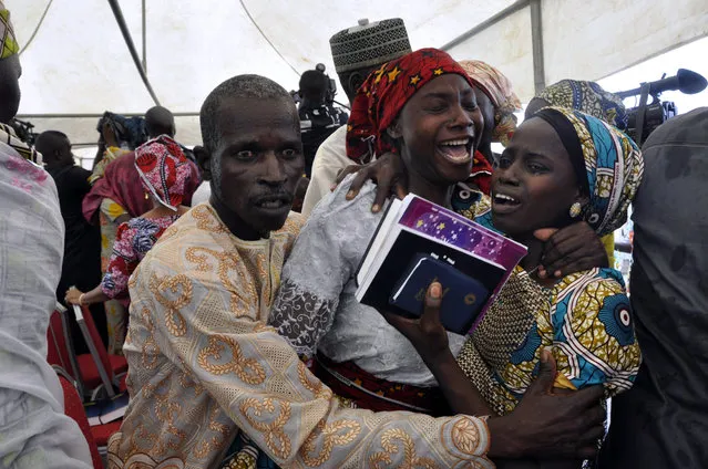 One of the kidnapped girls celebrates with family members during an church survives held in Abuja, Nigeria, Sunday, October 16, 2016. The girls were released Thursday and flown to Abuja, Nigeria's capital, but it's taken days for the parents to arrive. The families came from the remote northeastern town of Chibok, where nearly 300 girls were kidnapped on April 2014 in a mass abduction that shocked the world. Dozens of schoolgirls escaped in the first few hours but after last week's release, 197 remain captive. (Photo by Olamikan Gbemiga/AP Photo)