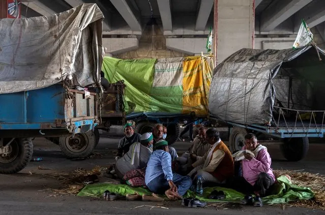 Farmers rest near their parked tractor trolleys at the site of a protest against the newly passed farm bills at the Delhi-Uttar Pradesh border in Ghaziabad, India, December 2, 2020. (Photo by Danish Siddiqui/Reuters)
