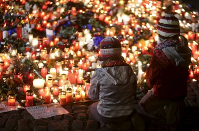 Children pray for the victims of the Paris attacks in front of the French embassy in Prague, Czech Republic, November 14, 2015. (Photo by David W. Cerny/Reuters)