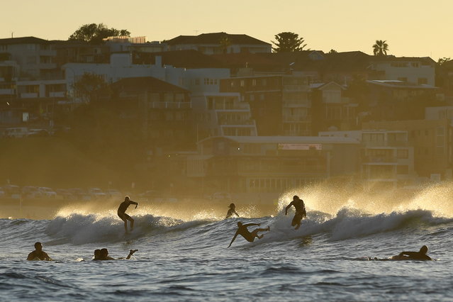 Surfers ride a wave during sunrise at Bondi Beach in Sydney, New South Wales, Australia, 05 April 2025. Daylight saving ends in Australia at 3am local time on 06 April when clocks go back one hour in NSW, Victoria, South Australia, Tasmania, and the ACT. (Photo by Steven Saphore/EPA)