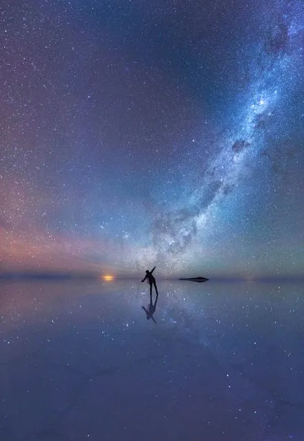 The Mirrored Night Sky. An enthralled stargazer is immersed in the stars as the luminous purple sky is mirrored in the thin sheet of water across the world’s largest salt flat, Salar de Uyuni, in Bolivia. (Photo by Xiaohua Zhao)