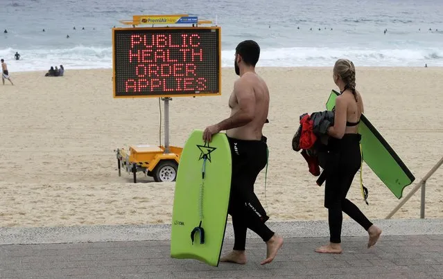 A sign warns people at a beach in Sydney, Australia, Saturday, December 19, 2020. Sydney's northern beaches will enter a lockdown similar to the one imposed during the start of the COVID-19 pandemic in March as a cluster of cases in the area increased to more than 40. (Photo by Mark Baker/AP Photo)