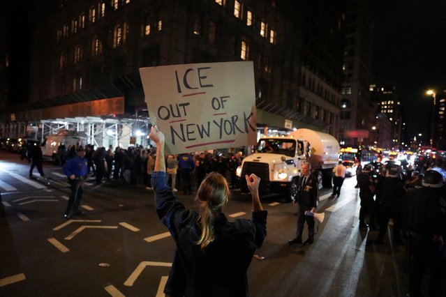 A protester holds a sign outside 26 Federal Plaza, where migrants who were detained during a raid in Lower Manhattan by ICE were brought in, in Manhattan, New York, U.S., October 21, 2025. (Photo by David Dee Delgado/Reuters)