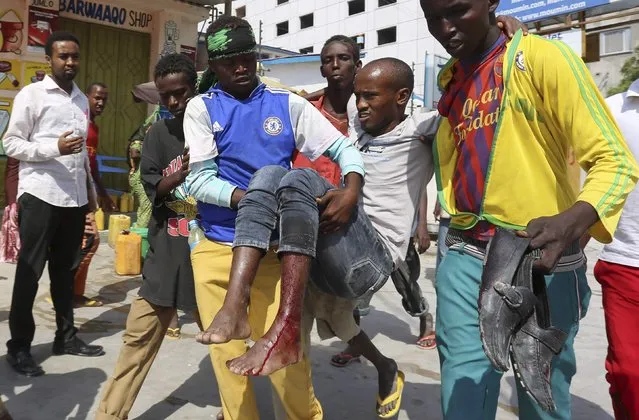 Residents evacuate a civilian injured in a car bomb explosion near the Taleex junction of Somalia's capital Mogadishu, January 2, 2015. One person, who was in the car when the explosion occurred, died in the incident, for which Al-Shabaab claimed responsibility, and three others were injured, according to local media. (Photo by Feisal Omar/Reuters)