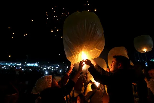 People light traditional home-made paper lanterns during the annual Tazaungdaing balloon festival in Taunggyi November 19, 2015. (Photo by Soe Zeya Tun/Reuters)