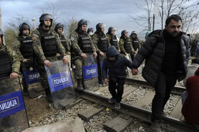 Macedonian policemen stand guard as migrants wait to cross the Greek-Macedonian borders near the village of Idomeni, Greece November 22, 2015. (Photo by Alexandros Avramidis/Reuters)