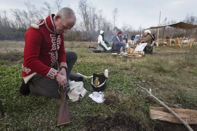 Michael Robertson of Toronto, Ontario, Canada, plays a British soldier, cleans his musket following a reenactment of the Battle of New Orleans in the War of 1812, marking its bicentennial in Chalmette, Louisiana January 10, 2015. (Photo by Lee Celano/Reuters)