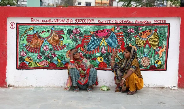 Indian women sit next to the Madhubani artwork at the Madhubani railway station in Bihar, India, 07 April 2018. (Photo by Harish Tyagi/EPA/EFE)
