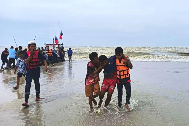 In this photo released by the People Unity Foundation, rescuers from the charitable organization help a survivor from a boat that capsized off the coast of Nakhon Sri Thammarat province, southern Thailand on April 16, 2023. A freak storm in southern Thailand capsized a dozen fishing boats and killed multiple people, but more than 100 others who were also at sea have been accounted for, officials said Monday. (Photo by People Unity Foundation via AP Photo)