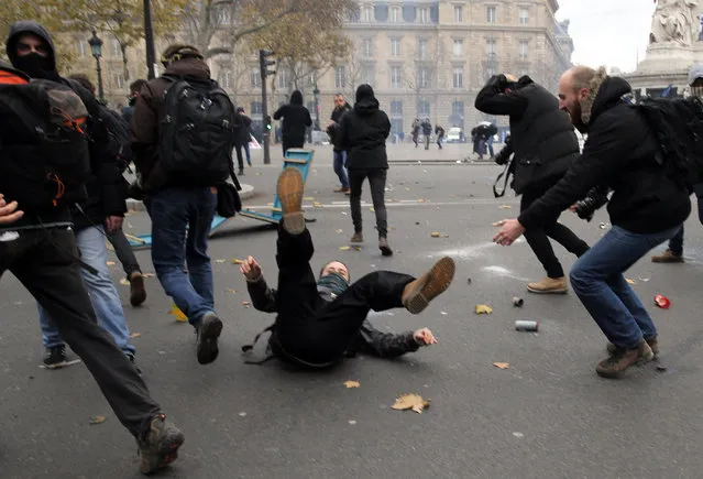 Activists fight with policemen during a protest ahead of the 2015 Paris Climate Conference, in Paris, Sunday, November 29, 2015. (Photo by Christophe Ena/AP Photo)
