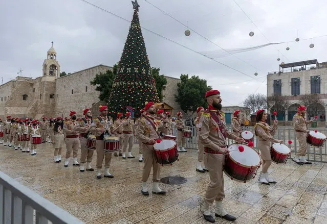 Palestinian scout bands parade through Manger Square at the Church of the Nativity, traditionally recognized by Christians to be the birthplace of Jesus Christ, ahead of the midnight Mass, in the West Bank city of Bethlehem, Thursday, December 24, 2020. Few people were there to greet them as the coronavirus pandemic and a strict lockdown dampened Christmas Eve celebrations. (Photo by Nasser Nasser/AP Photo)