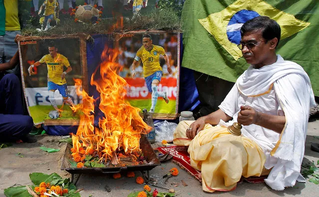 A soccer fan performs “havan” (traditional Hindu fire ritual) as part of a special prayer for the better performance and win for Brazil in the FIFA World Cup 2018 in Russia, at Howrah on the outskirts of  Kolkata, India, June 14, 2018. (Photo by Rupak De Chowdhuri/Reuters)
