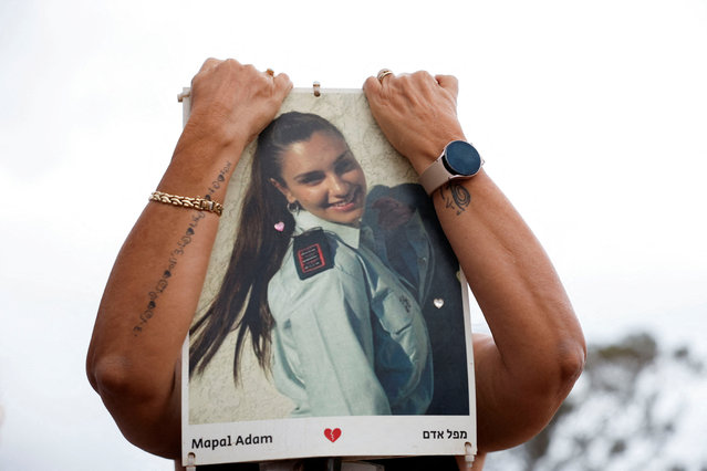 A person holds up a poster of Mapal Adam, who was killed during the October 7 attack by Hamas, at a gathering to mark one year since partygoers were killed and kidnapped during the deadly attack, at the site of the Nova festival in Reim, southern Israel, on October 7, 2024. (Photo by Amir Cohen/Reuters)
