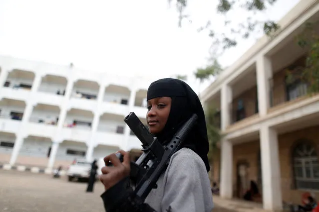 A girl displaced by the fighting in the Red Sea port city of Hodeidah holds a toy rifle at a school where IDPs live in Sanaa, Yemen on June 26, 2018. (Photo by Khaled Abdullah/Reuters)