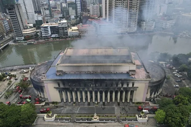Smoke billows from the still smoldering Manila Central Post Office as a fire hits early Monday, May 22, 2023 in Manila, Philippines. A massive fire tore through Manila's historic post office building overnight, police and postal officials said Monday. (Photo by Aaron Favila/AP Photo)