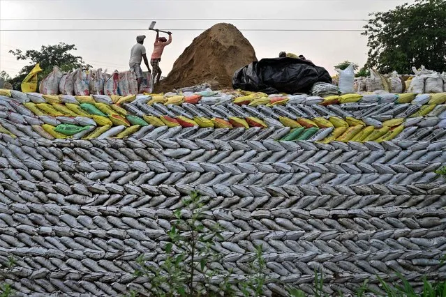 In this photograph taken on Juy 17, 2023, labourers work at the construction site of a national highway in Jalandhar. (Photo by Shammi Mehra/AFP Photo)