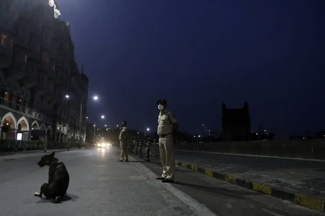 Security personnel guard near Gateway of India monument in Mumbai, India, Wednesday April 14, 2021. The teeming metropolis of Mumbai and other parts of Maharashtra, the Indian state worst hit by the pandemic, face stricter restrictions for 15 days starting Wednesday in an effort to stem the surge of coronavirus infections. (Photo by Rajanish Kakade/AP Photo)