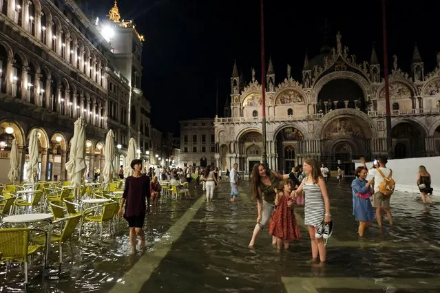 Tourists walk through flooded St Mark's Square after unusually high water levels in Venice, Italy on August 1, 2023. (Photo by Manuel Silvestri/Reuters)
