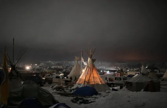 Night falls on Oceti Sakowin Camp on the edge of the Standing Rock Sioux Reservation on December 1, 2016 outside Cannon Ball, North Dakota. Native Americans and activists from around the country have been gathering at the camp for several months trying to halt the construction of the Dakota Access Pipeline. The proposed 1,172-mile-long pipeline would transport oil from the North Dakota Bakken region through South Dakota, Iowa and into Illinois. (Photo by Scott Olson/Getty Images)