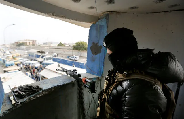 A member of the Iraqi security forces stands guard in the watchtower as concrete blockades are lifed in order to remove checkpoints, in Baghdad, Iraq December 20, 2016. (Photo by Ahmed Saad/Reuters)