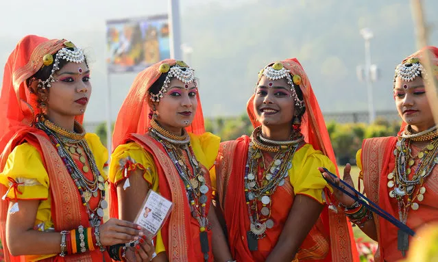 Traditional Indian folkdancers from the state of Madhya Pradesh look on at the inauguration ceremony for the “Statue Of Unity”, the world' s tallest statue dedicated to Indian independence leader Sardar Vallabhbhai Patel, overlooking the Sardar Sarovar Dam near Vadodara in India' s western Gujarat state on October 31, 2018. India on October 31 inaugurated the world' s biggest statue with pomp, fireworks and tight security amid an outcry among local groups over the cost of the 182 metre (600 feet) high reproduction of an Indian independence hero. (Photo by Sam Panthaky/AFP Photo)